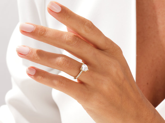 Heart shaped moissanite pave shoulder ring in rose gold worn on the ring finger