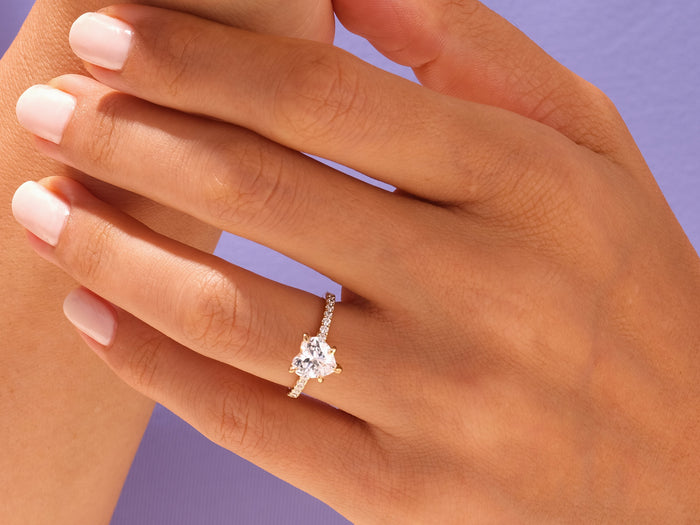 Large heart moissanite pave shank ring in rose gold worn on the hand