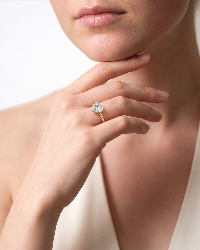 Large heart lab grown diamond solitaire worn on the hand at the chin