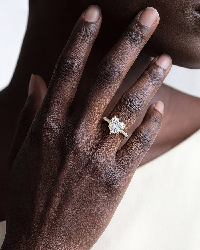 Large heart moissanite twisted band ring in yellow gold worn on the hand, close view