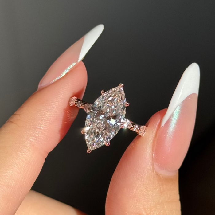Marquise moissanite engagement ring with marquise and round accent shoulders in rose gold
