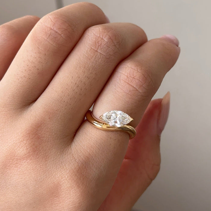 East west marquise moissanite curved band solitaire engagement ring in yellow gold