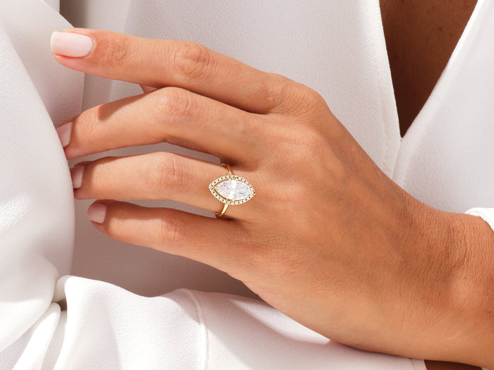 Marquise moissanite halo ring in yellow gold worn on the ring finger