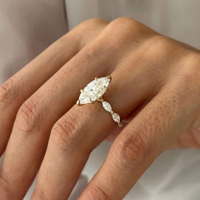 Marquise cut moissanite engagement ring with marquise and round accent shoulders in yellow gold, view 2