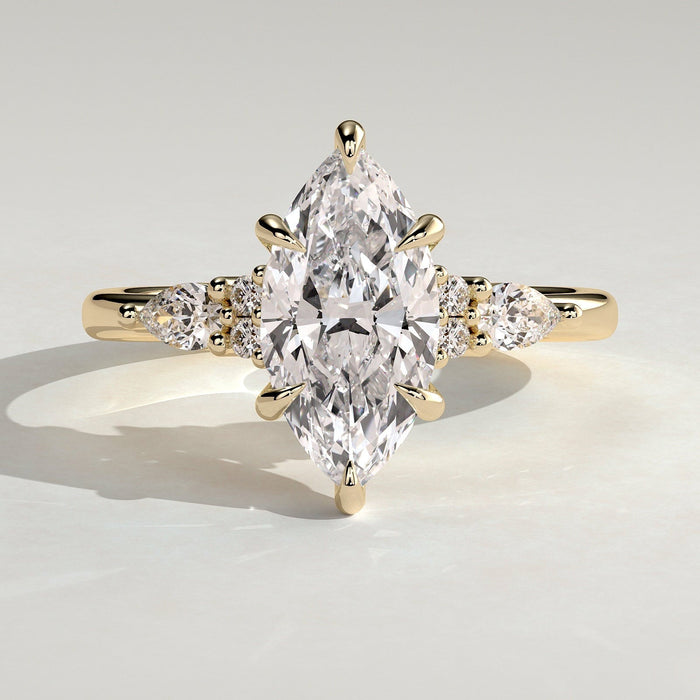 Marquise moissanite engagement ring with pear and round cluster shoulders in yellow gold