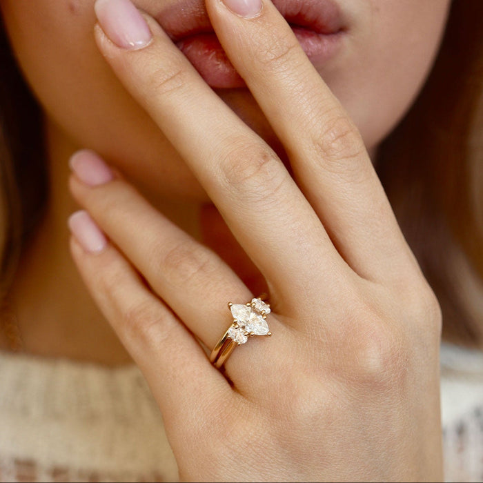Marquise cut moissanite petite three stone engagement ring with pear side stones in yellow gold