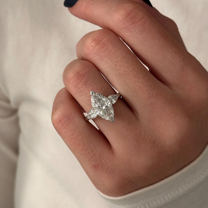 Marquise cut moissanite three stone engagement ring with pear side stones in white gold