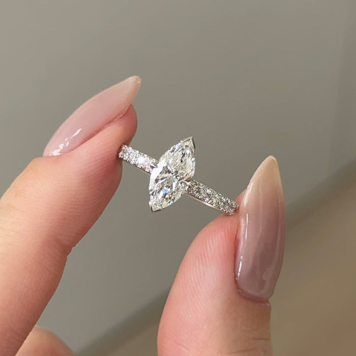 Marquise cut moissanite solitaire engagement ring on a pave set white gold band