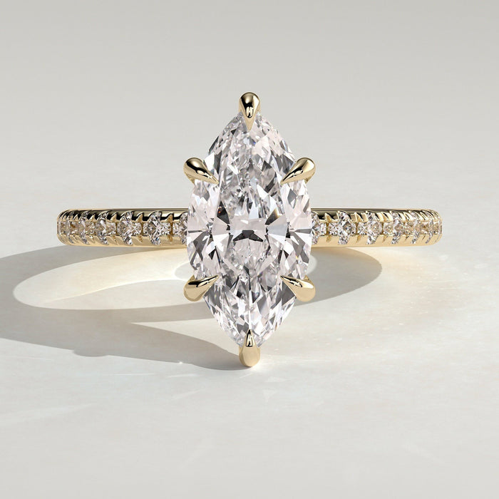 Marquise cut moissanite six claw engagement ring on a pave yellow gold band