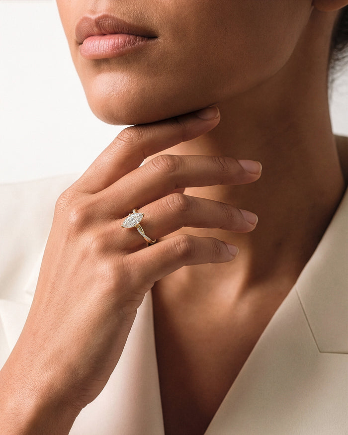 Marquise lab grown diamond twisted pave ring worn on the hand at the chin