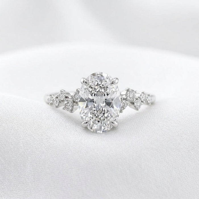 Oval cut moissanite engagement ring with alternating offset accents on the shank in white gold