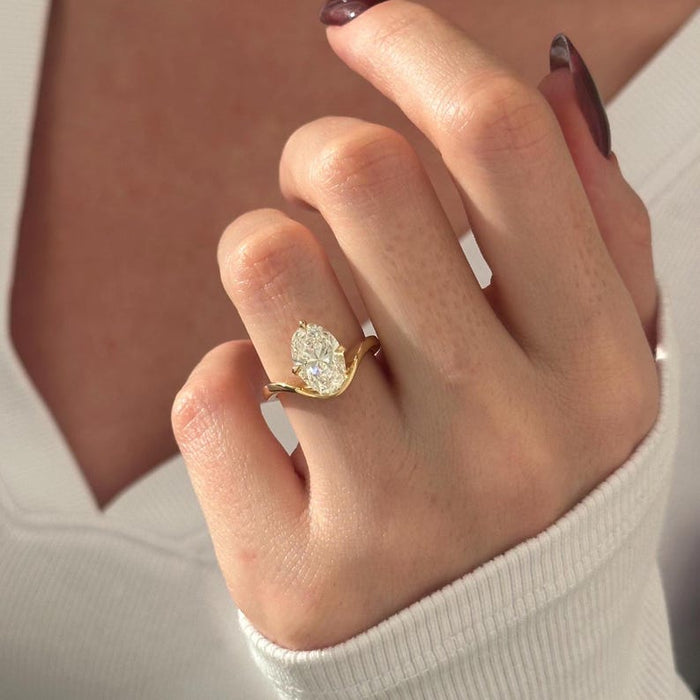 Oval cut moissanite curved bypass solitaire engagement ring in yellow gold