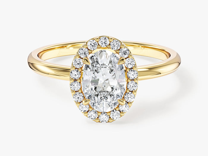 Dainty oval halo moissanite engagement ring on a thin plain band in yellow gold, front view