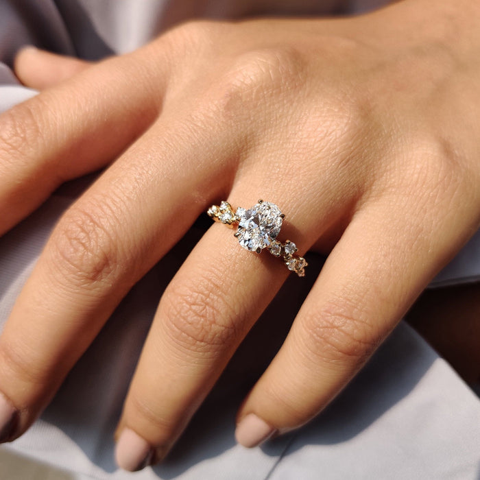 Oval cut moissanite engagement ring with claw set graduated accents winding down a vine shank, view 2