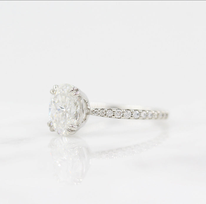 Oval cut moissanite double claw engagement ring on a French pave band in white gold, view 2