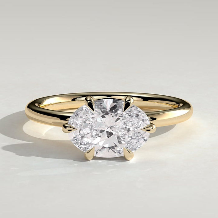 East west oval moissanite six claw solitaire engagement ring on a plain yellow gold band
