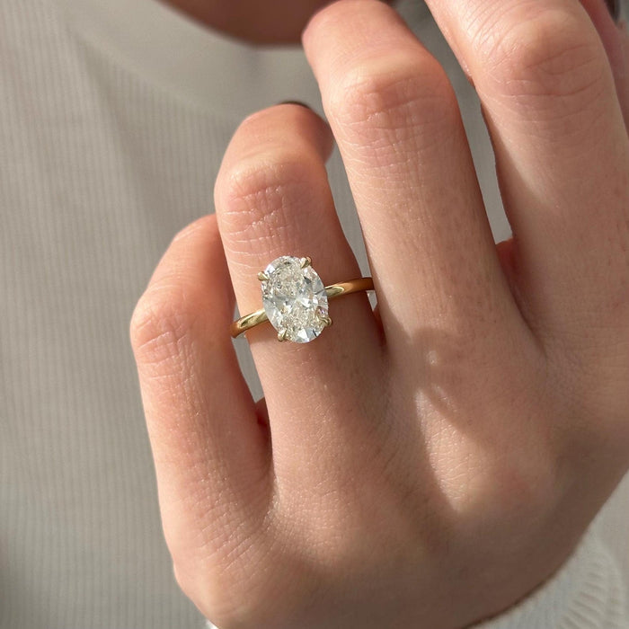 Oval cut moissanite hidden halo engagement ring in yellow gold