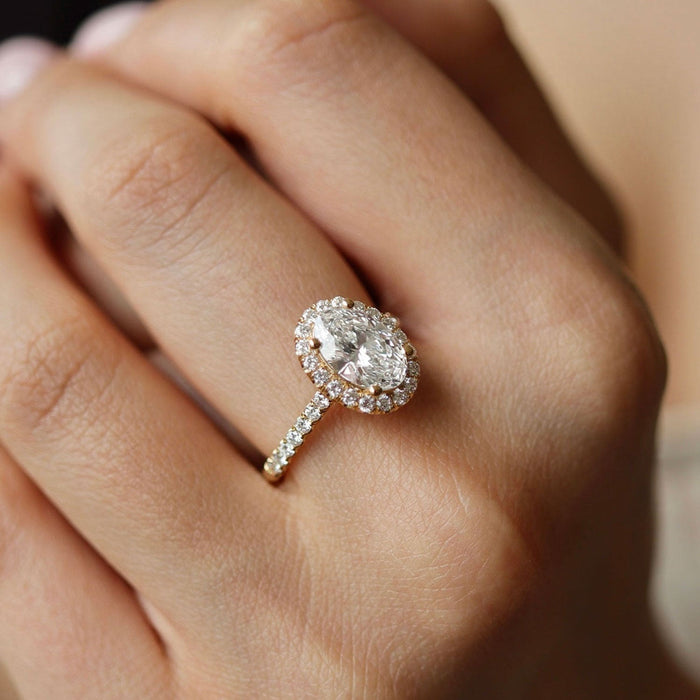 Oval cut moissanite halo engagement ring with pave band in yellow gold, view 2