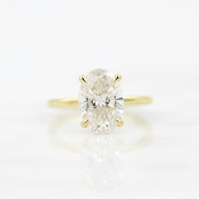 Large oval cut moissanite solitaire engagement ring on a hairline wire yellow gold band
