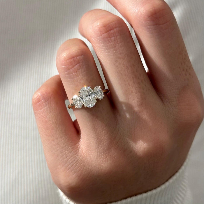 Oval cut moissanite three stone engagement ring with oval side stones in yellow gold, view 2