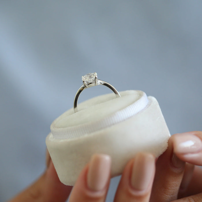 Oval cut moissanite solitaire engagement ring on a pinched tapered hairline band in white gold, view 2