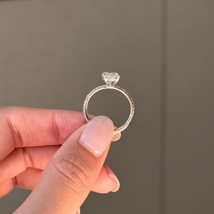 Oval cut moissanite solitaire engagement ring on a pave set white gold band, view 2