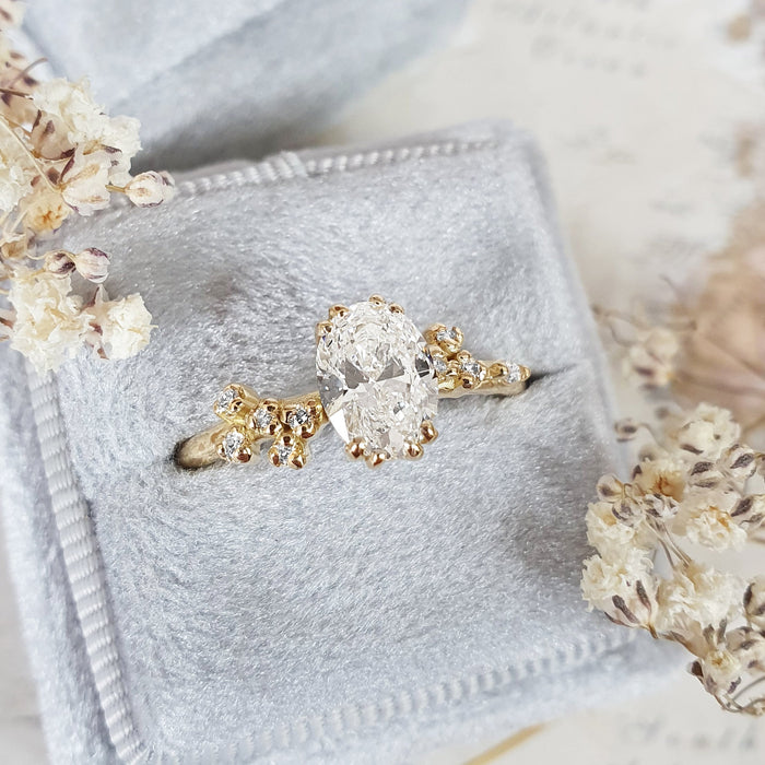 Oval cut moissanite double claw engagement ring with scattered cluster shoulders in yellow gold, view 2
