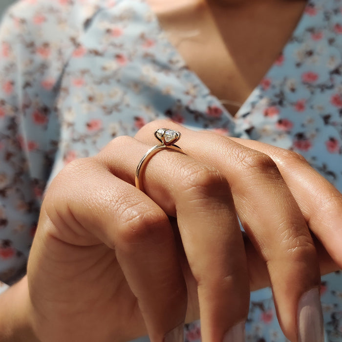 Oval cut moissanite six claw solitaire engagement ring on a domed rose gold band, view 2