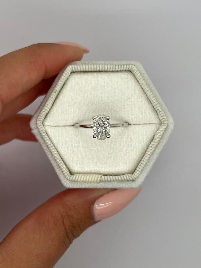 Oval cut moissanite six claw solitaire engagement ring on a fine white gold band
