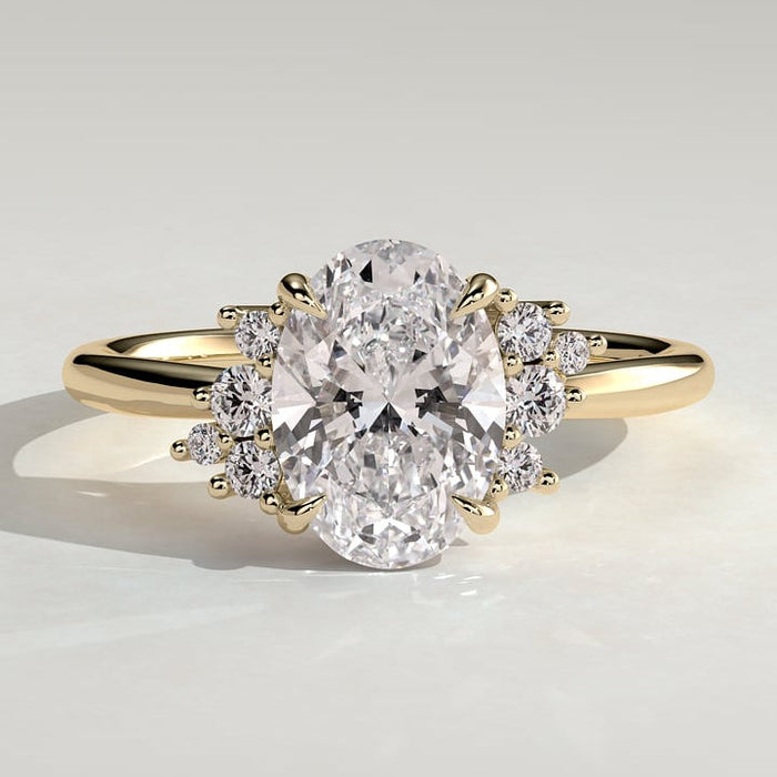 Oval cut moissanite scattered cluster shoulder engagement ring in yellow gold