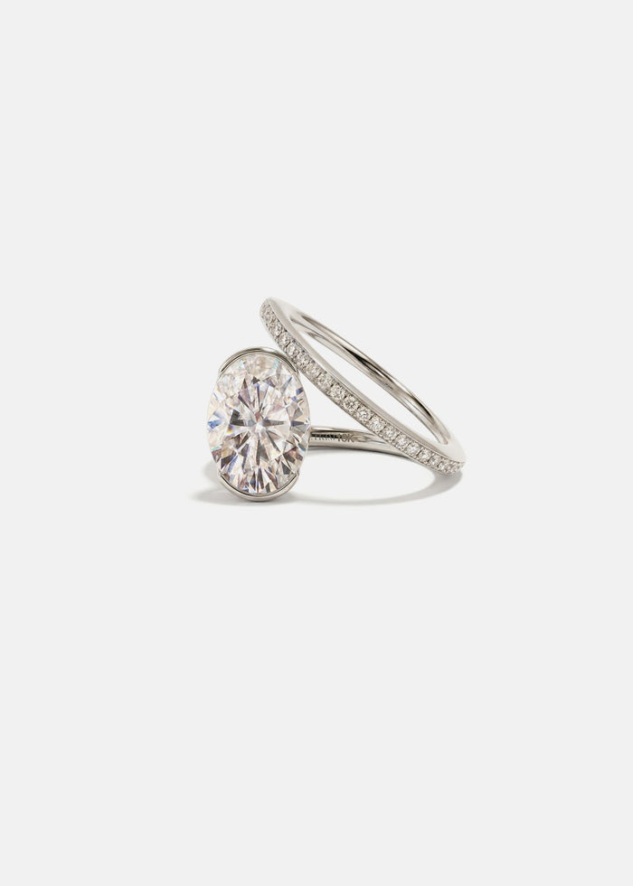 Oval cut moissanite bezel set engagement ring on a spiral pave band in yellow gold, view 2