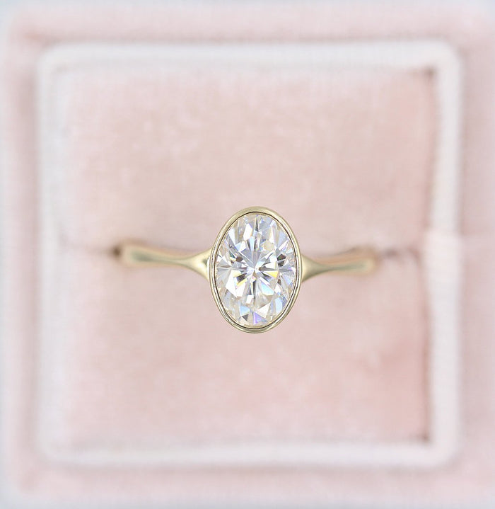 Oval cut moissanite tapered bezel solitaire engagement ring in yellow gold, view 2