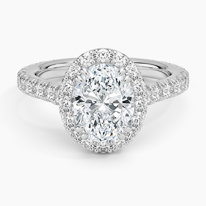 Oval moissanite in a full halo with three quarter pave band in white gold