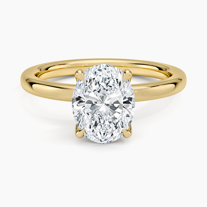 Oval moissanite solitaire on a heavy domed yellow gold band, top view