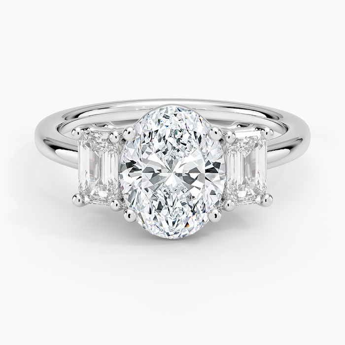 Oval moissanite three stone ring with emerald cut sides in white gold, top view