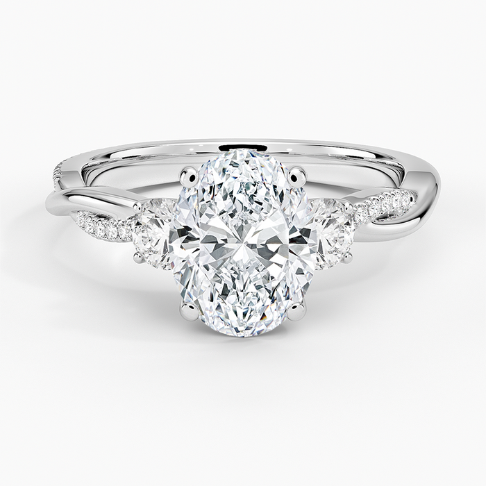 Oval moissanite with half moon side stones on a twisted pave white gold band