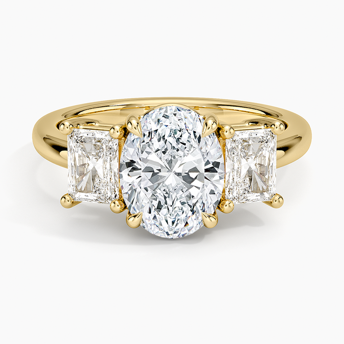 Oval moissanite with two radiant cut side stones in yellow gold, top view