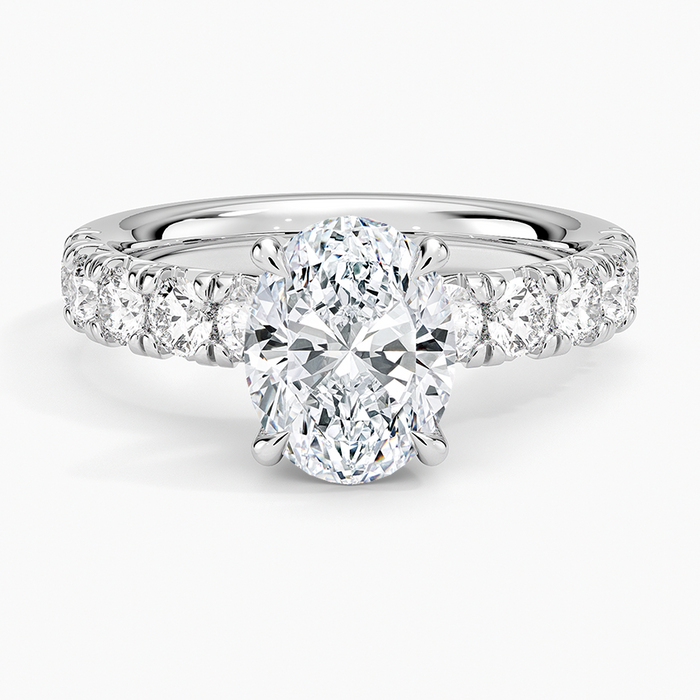 Oval moissanite on a large shared prong accent band in white gold, top view