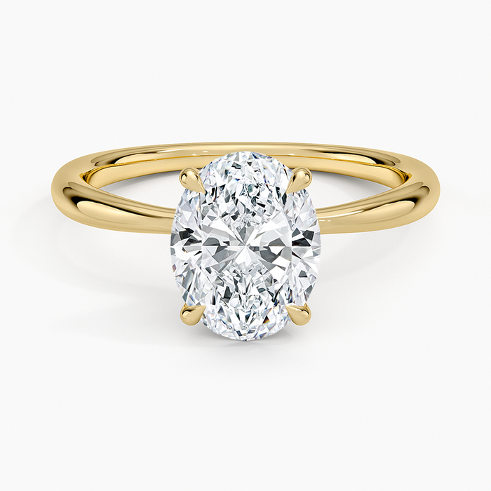 Oval moissanite petite tapered solitaire engagement ring in yellow gold, top view