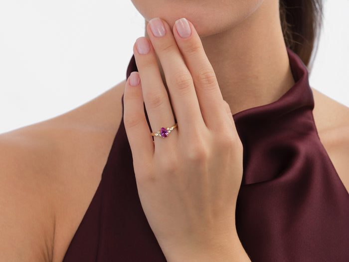 Pear moissanite cluster engagement ring worn on the hand held to the chin