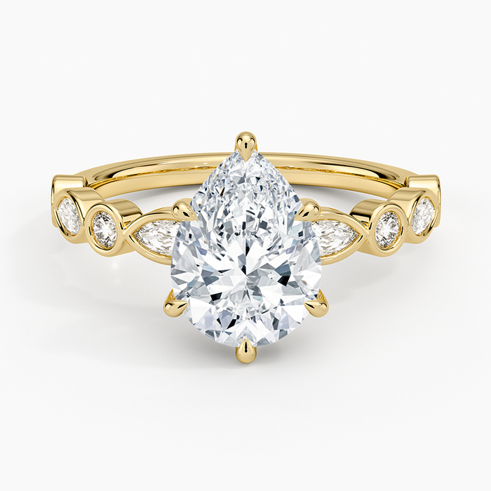 Pear cut moissanite bezel set marquise and round engagement ring in yellow gold, top view