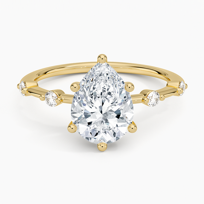Pear cut moissanite graduated spaced accent engagement ring in yellow gold, top view