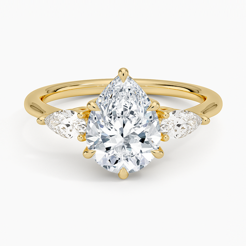 Pear cut moissanite with two small east west pear side stones on a slim band in yellow gold, top view