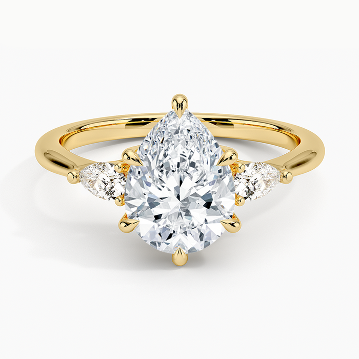 Pear cut moissanite three stone engagement ring in yellow gold, top view