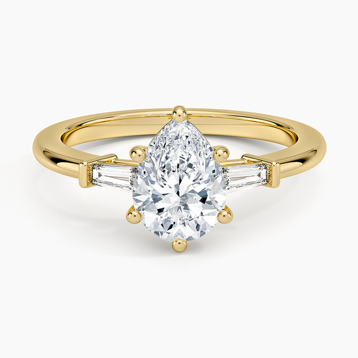 Pear cut moissanite tapered baguette three stone engagement ring in yellow gold, top view