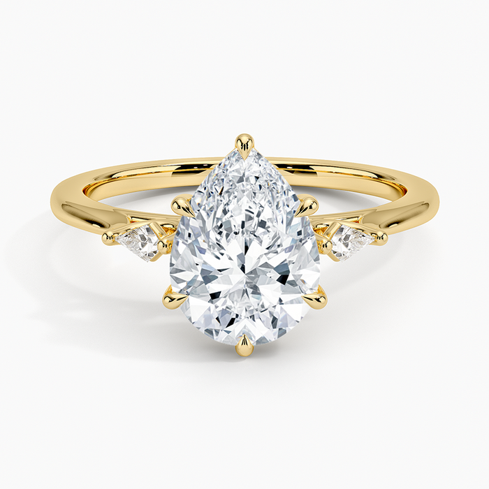 Pear cut moissanite petite kite three stone engagement ring in yellow gold, top view