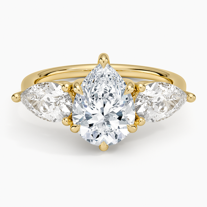 Pear cut moissanite with two east west pear side stones in yellow gold, top view