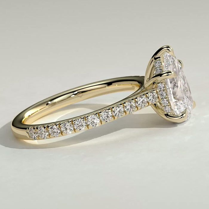 Pear cut moissanite five claw engagement ring on a fine pave yellow gold band, view 2