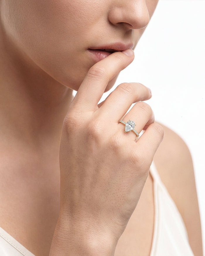 Pear lab grown diamond pave ring worn on a hand raised to the lips