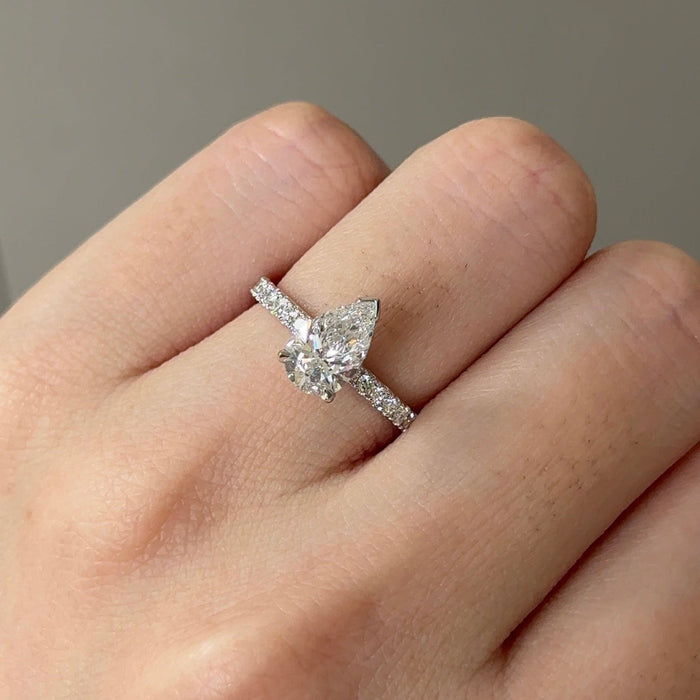 Pear cut moissanite solitaire engagement ring on a pave set white gold band, view 2